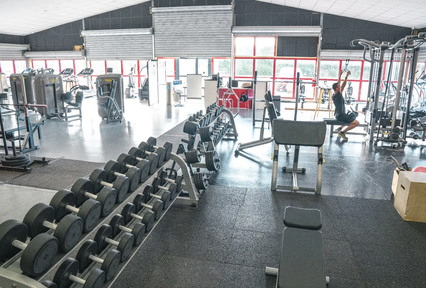 Rack d'haltères et machines guidées sur le plateau de musculation