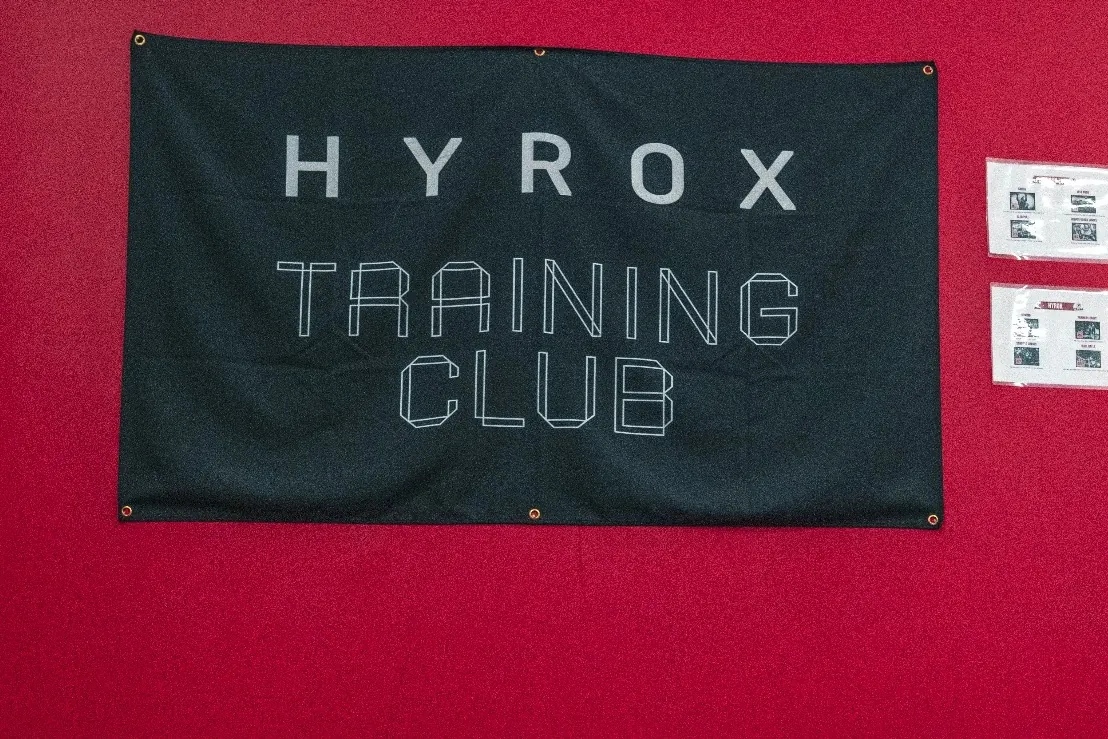 Adhérent en gainage devant le mur rouge Hyrox Training Club